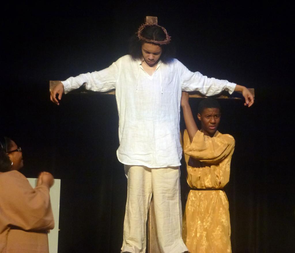 Crowning moment: Senior Khalid Bates as Jesus bears a crown of thorns while crucified on a wooden cross. Beside him is senior Dantel Shaw, playing the role of Peter, while Southfield-Lathrup sophomore Lindsey Hoper as a townsperson mourns the death of her savior. - Loren Coleman