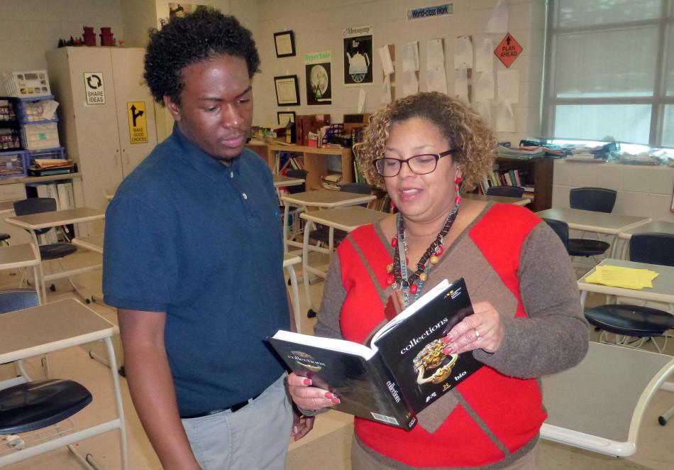 Read all about it: Junior Darian Fountain looks at the new English textbooks ordered for next year with English teacher Virna Hobbs-Calhoun.
