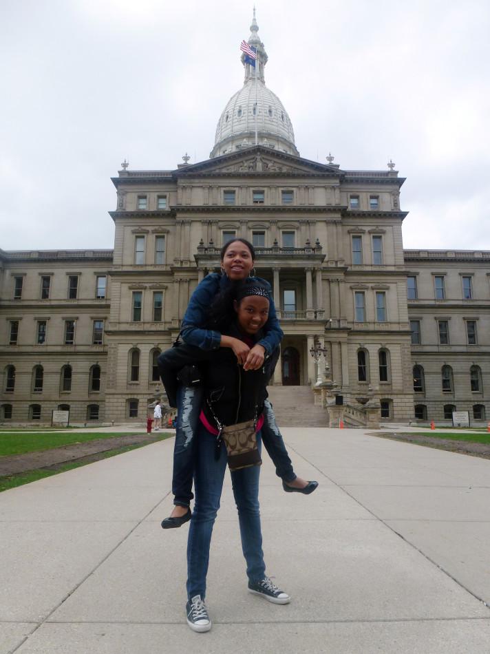 Champ: Senior Paige Hall celebrates her first place win with a piggy back ride from Southfield Jay staff writer Sahara Ashford in front of the State Capitol, in Lansing. 