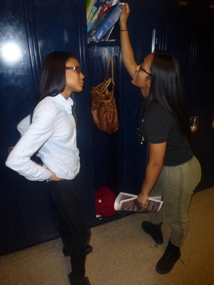 Booked: Junior Malaya Watson (right) grabes her literature book out of her locker as junior and friend Kyra Gradford-Dye looks on.