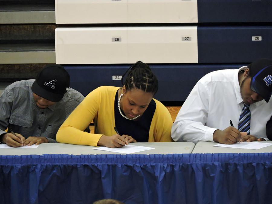 Seniors JaMar Antwine (left), Katherine Nealy (center),  and Calvin Graves (right) all sign their letters of intent. Antwine signed with Atlanta Sports Academy to play football, Nealy signed with The University of Michigan-Dearborn to play volleyball and Graves signed with Grand Valley State University to play football.