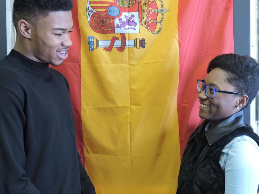 Junior Delan Wynn and sophomore Asia  Holmes practice their Spanish dialogue in Spanish class in front of the Spanish flag.