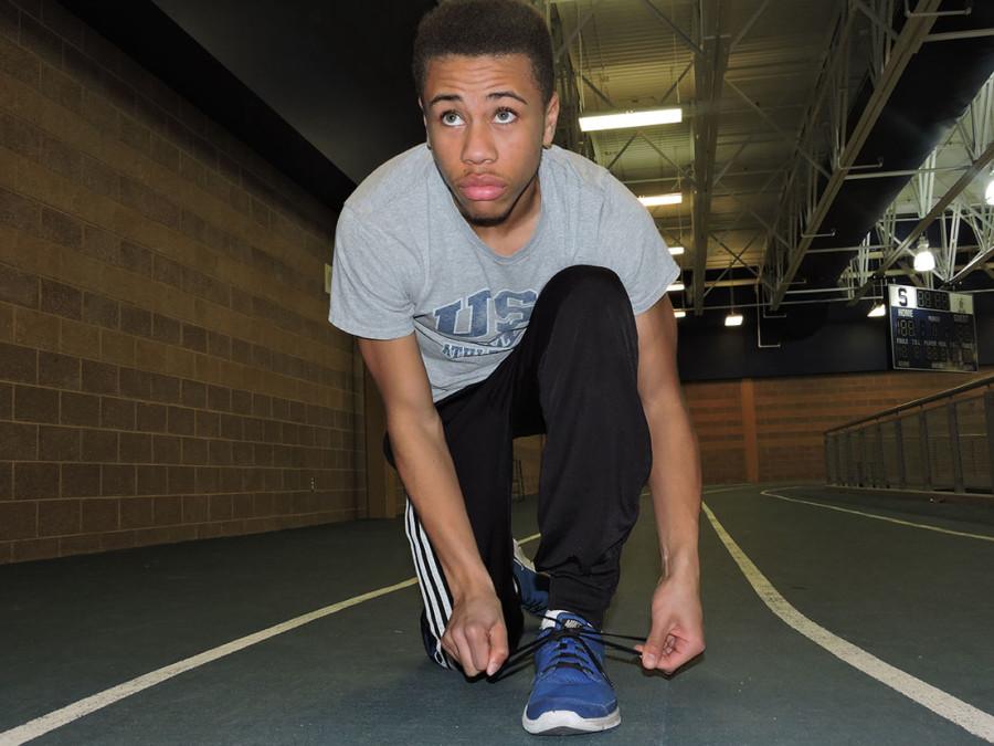 Senior Devin McLeod laces up his running shoes before using the schools indoor track to condition.
