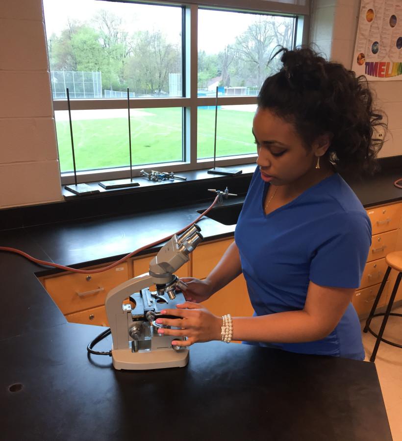 Close up: Future nurses assistant Ariell Sydes scopes out a microscope in science teacher Fred Pelleritos classroom. Sydes will start training this summer at William Beaumont Hospital, in Royal Oak, She already owns scrubs.