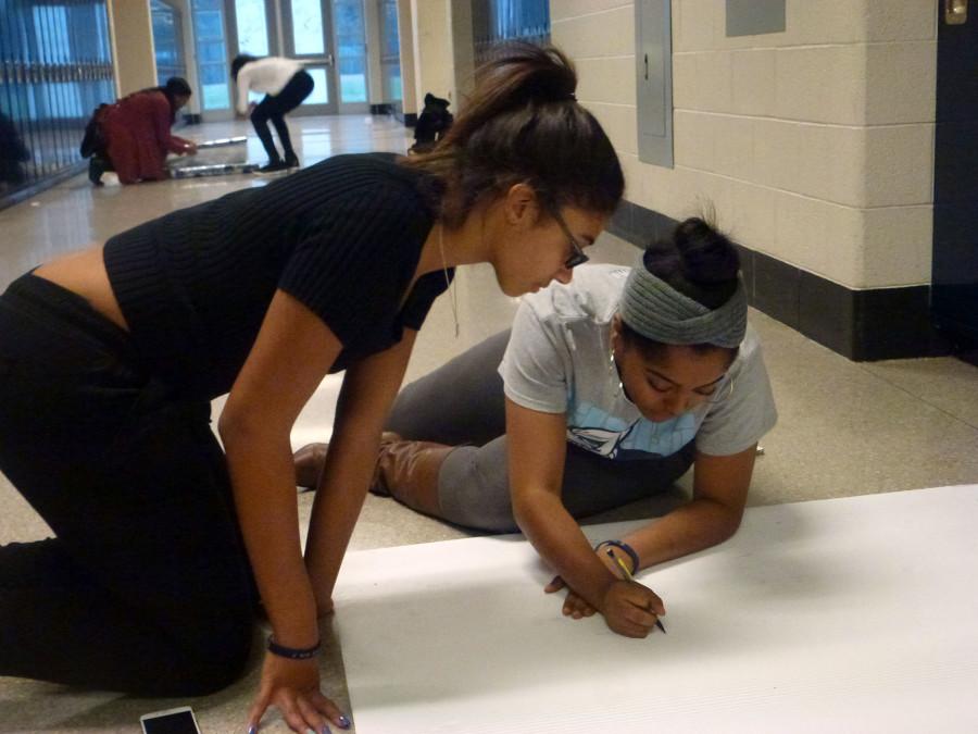 Sophomore members of the Southfield Student Congress Alaris Wiggins and Mya Brooks collaborate on a wall decoration for the hall decorating contest.