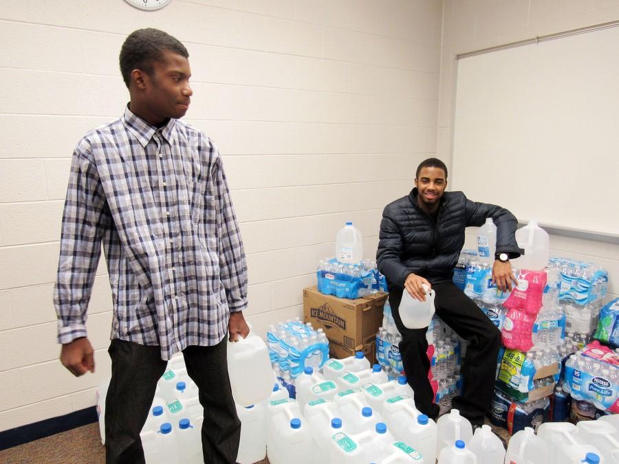 Members+of+the+Man+Up+group+organize+donated+water+for+the+Flint+water+crisis.+The+Red+Cross+has+agreed+to+transport+the+water+to+Flint.++Pictured+are+sophomore+Ronald+Canty+%28standing%29+and+junior+Julien+Wilson.