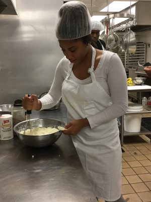 Junior Kyra Watts-Jackson mashes potatoes for her culinary arts class. 