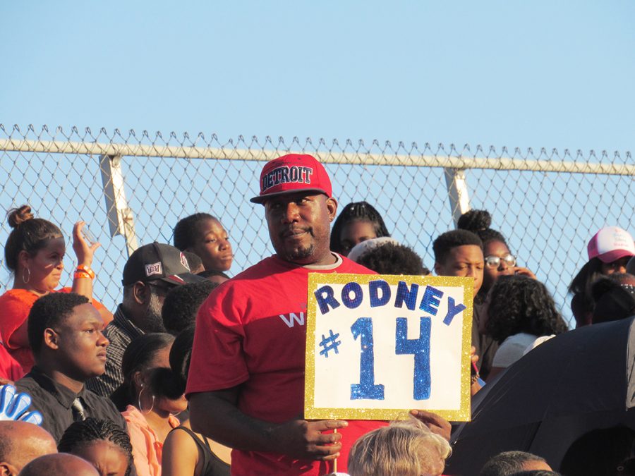 The number one fan of Rodney Harrington, football player #14, is his father, who sports a Rodney #14 sign at the Homecoming football game. 